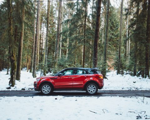 red suv on snow covered road during daytime