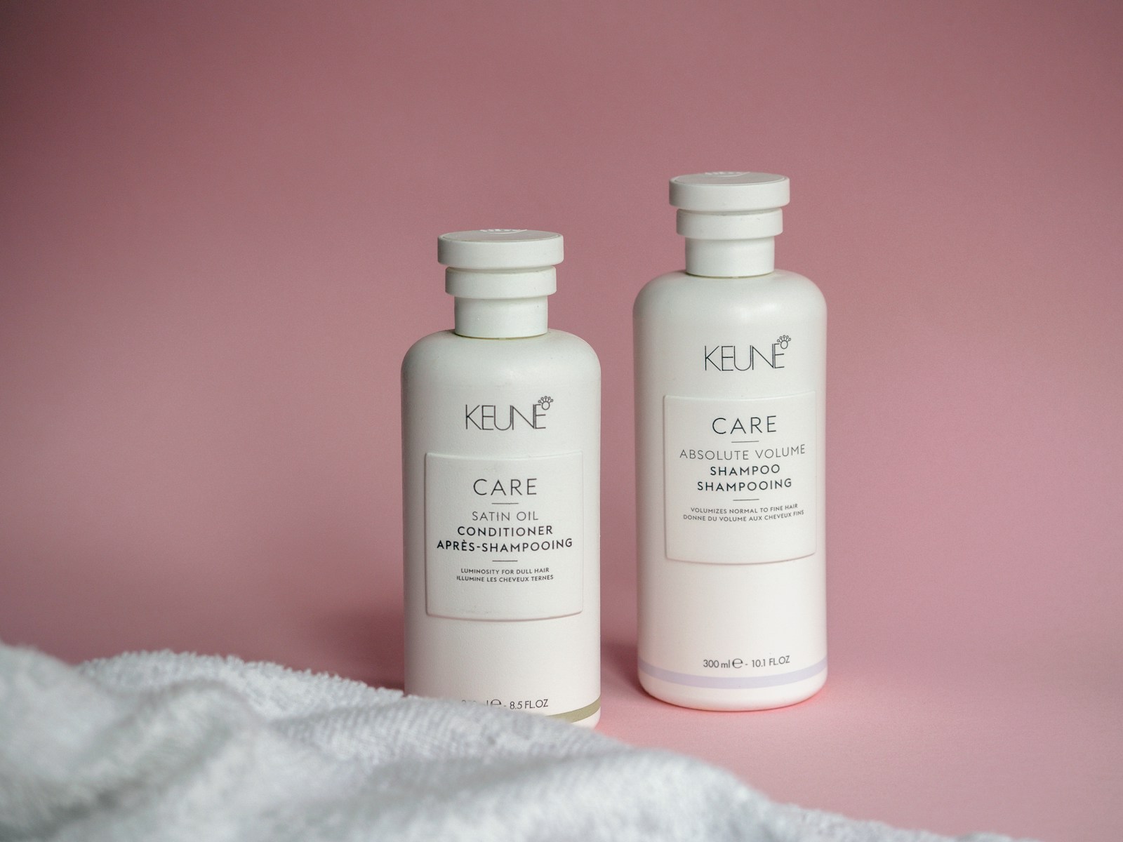 two bottles of keune care on a pink background