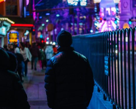 two people walking down a sidewalk at night