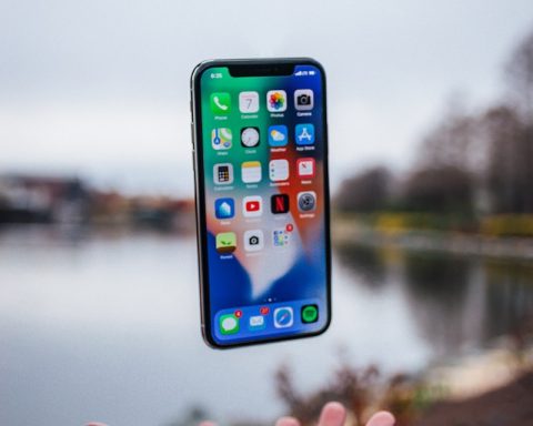 silver iPhone X floating over open palm