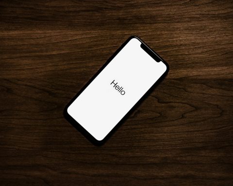 turned on iPhone on top of brown wooden surface