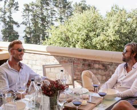 a group of men sitting at a table with wine glasses