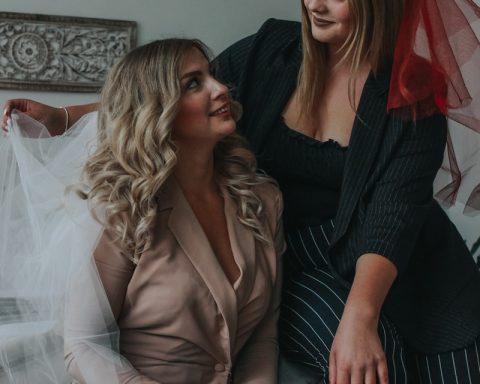 woman in black long sleeve shirt sitting beside woman in brown blazer