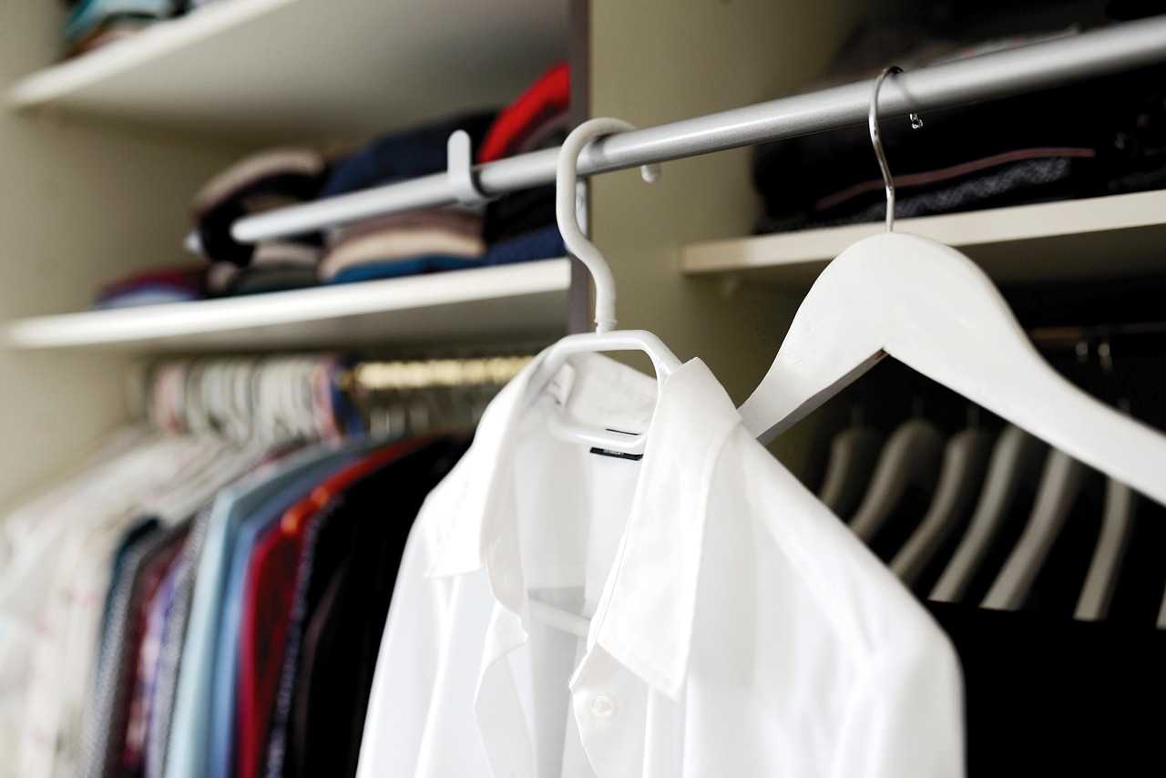 Man die zijn garderobe organiseert en kleding sorteert