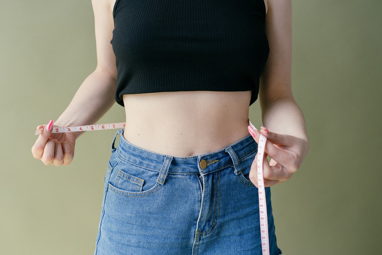 Een gespierde man die zijn tailleomtrek meet als alternatief voor BMI-meting