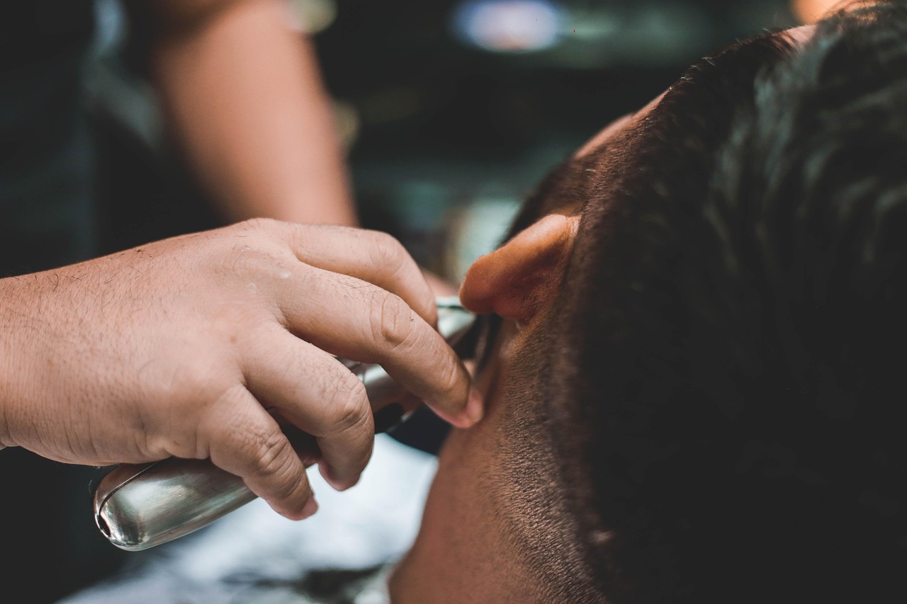 Man die bij de kapper zit voor een haarbehandeling